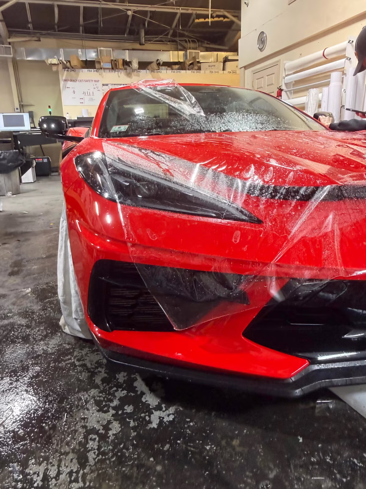 Paint protection film being installed on a red Chevrolet Corvette